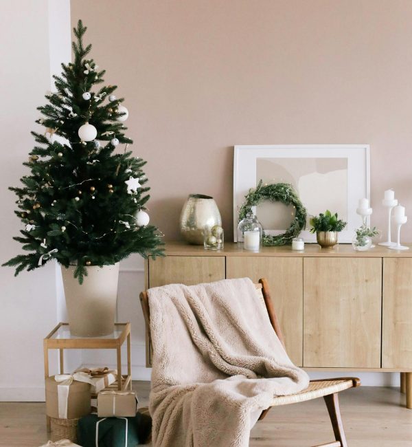 Stylish Christmas tree and gifts in a modern minimalist living room setting.